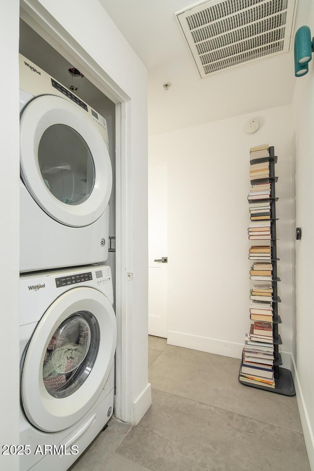 washroom featuring stacked washing maching and dryer