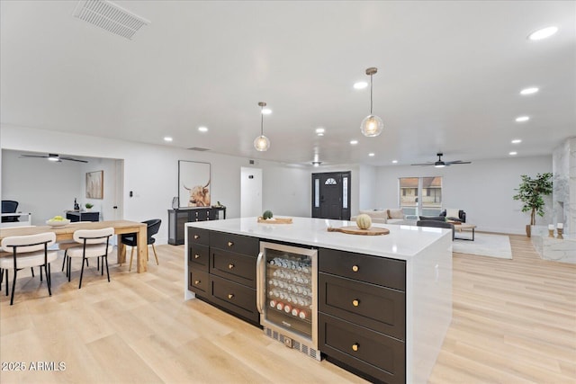 3506 W Yucca St, Phoenix, AZ 85029 - kitchen with beverage cooler, a ceiling fan, light wood finished floors, light countertops, and recessed lighting
