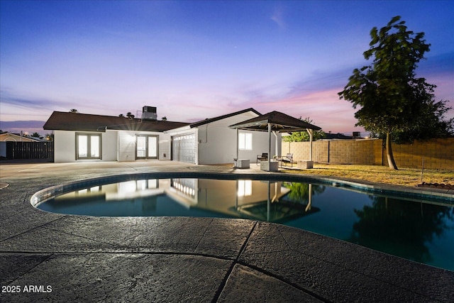 3506 W Yucca St, Phoenix, AZ 85029 - pool at dusk with french doors and a patio area