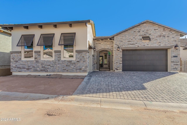 5741 E Star Valley St, Mesa, AZ 85215 - view of front of property featuring stone siding, stucco siding, an attached garage, and decorative driveway