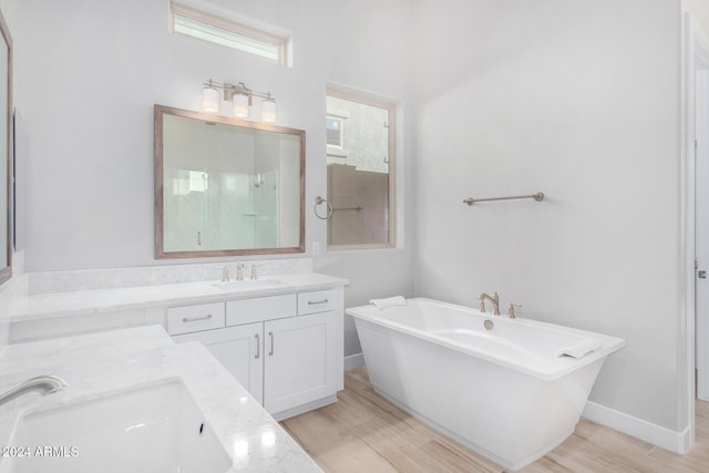 bathroom with wood-type flooring, independent shower and bath, and vanity