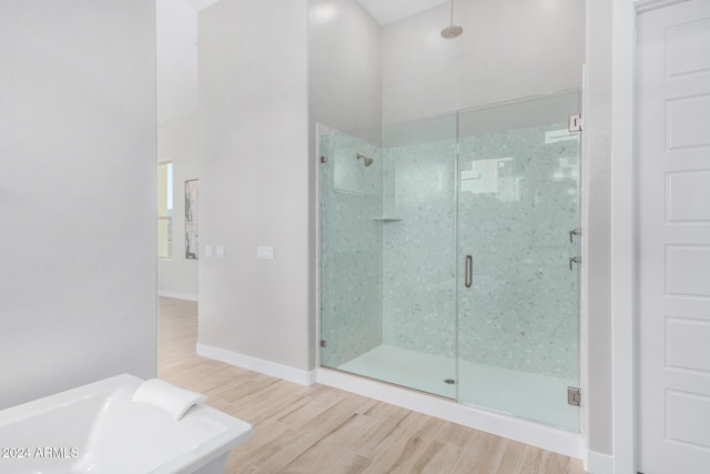 bathroom with wood-type flooring and independent shower and bath