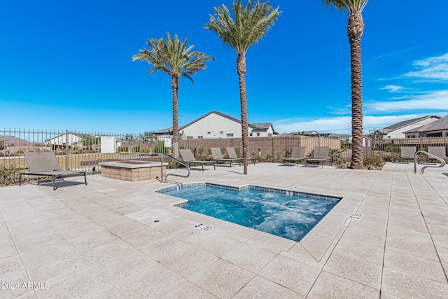 view of swimming pool with a hot tub and a patio