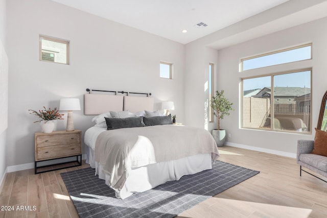 bedroom featuring multiple windows and light hardwood / wood-style flooring