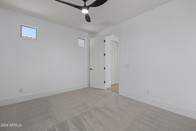 spare room with light colored carpet and ceiling fan