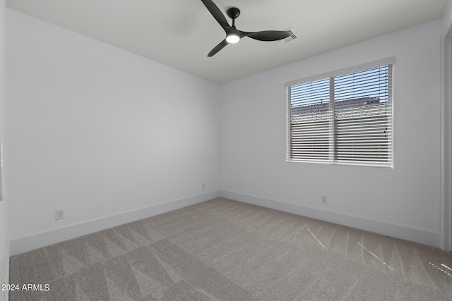 spare room with ceiling fan and light colored carpet