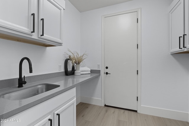 interior space featuring white cabinets, light hardwood / wood-style floors, and sink