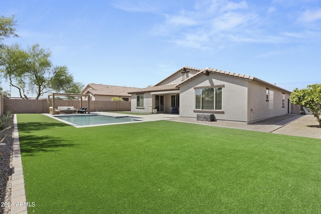 rear view of house with a fenced in pool, a patio area, and a yard