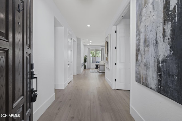 corridor with light hardwood / wood-style floors