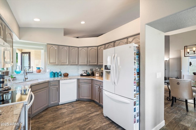 kitchen featuring white appliances, dark wood-type flooring, gray cabinets, and backsplash