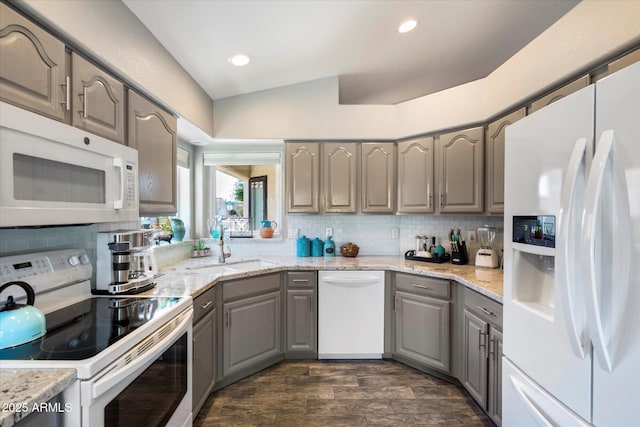 kitchen with tasteful backsplash, recessed lighting, white appliances, and gray cabinetry