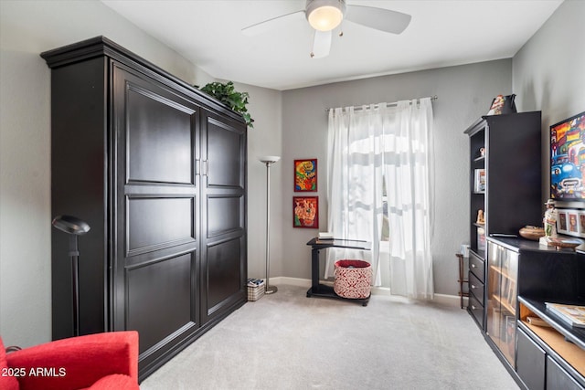 interior space with light colored carpet, ceiling fan, and baseboards