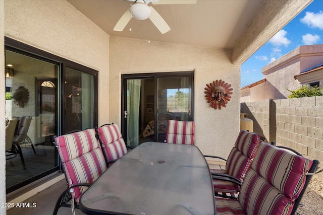 view of patio featuring outdoor dining area, ceiling fan, and fence