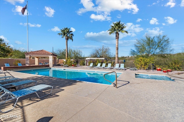 pool with a gazebo, fence, and a patio