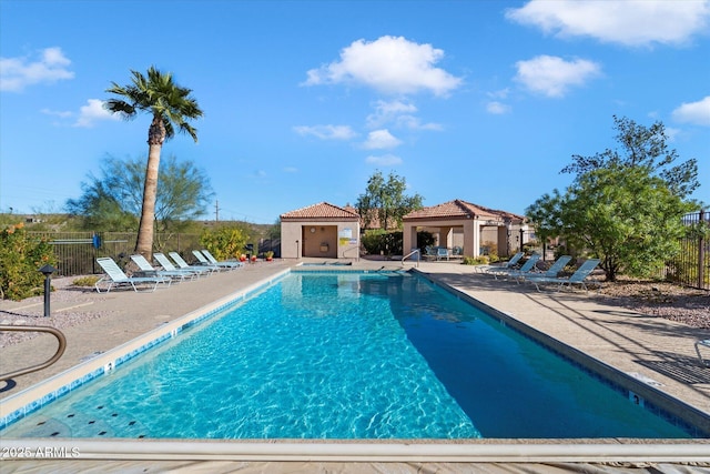 community pool with a patio, a gazebo, and fence