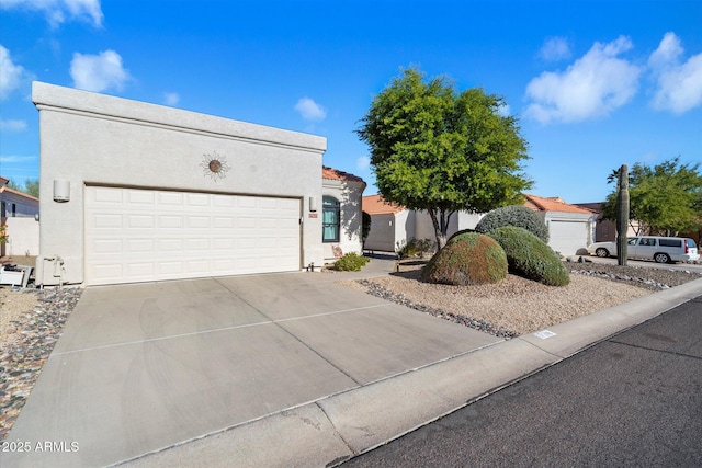 view of front of home with a garage, driveway, and stucco siding