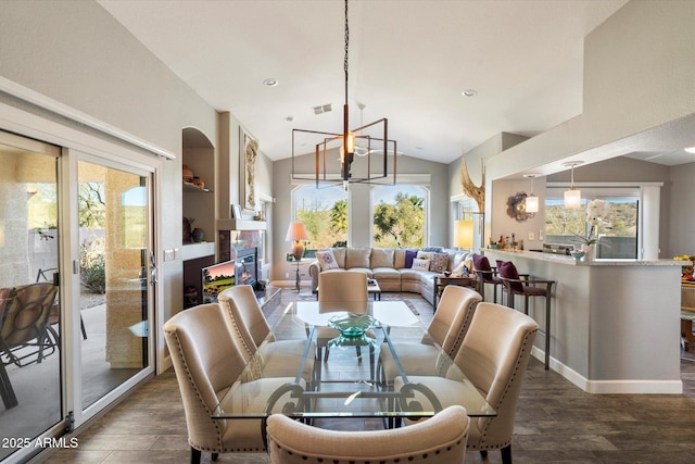 dining area with lofted ceiling, plenty of natural light, and dark wood finished floors