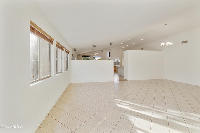 spare room featuring light tile patterned flooring, a chandelier, and lofted ceiling