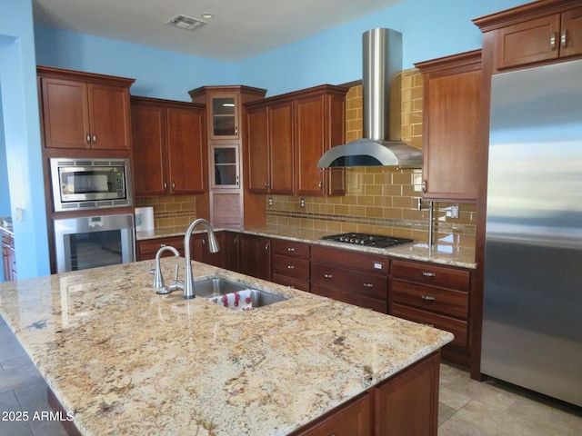 kitchen with decorative backsplash, beverage cooler, wall chimney range hood, a sink, and stainless steel appliances