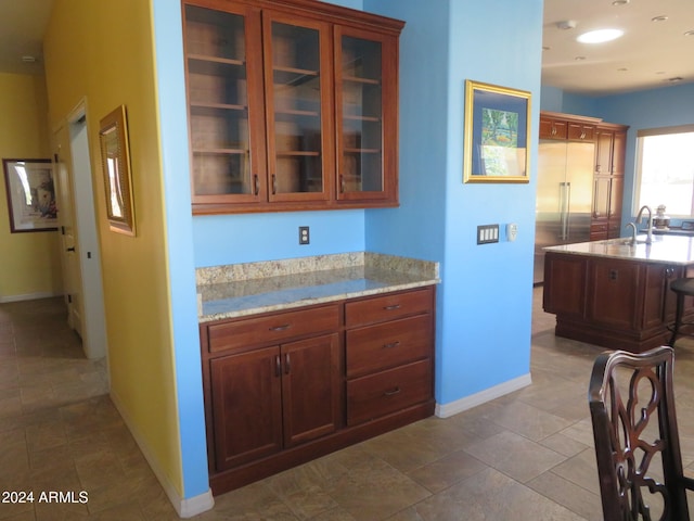 kitchen with high quality fridge, sink, and light stone countertops