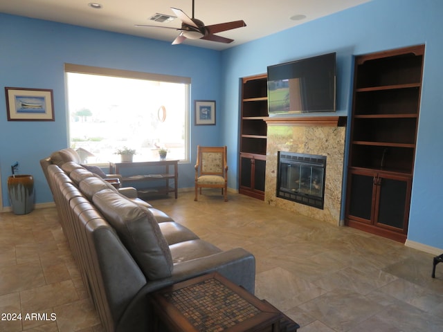 living room with ceiling fan and a fireplace