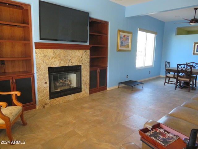 living room with a premium fireplace and ceiling fan