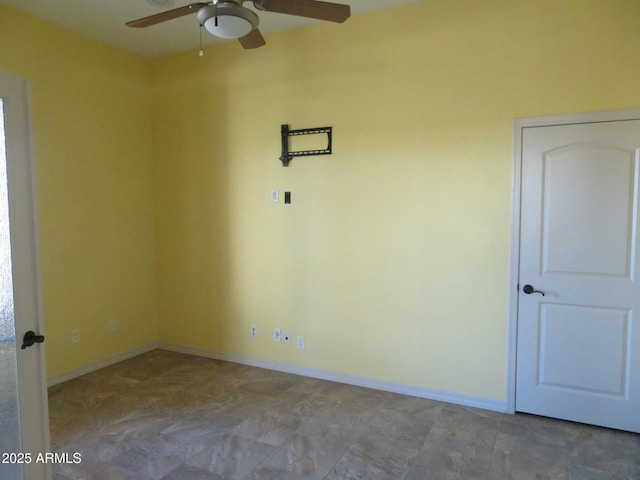 spare room featuring baseboards and ceiling fan