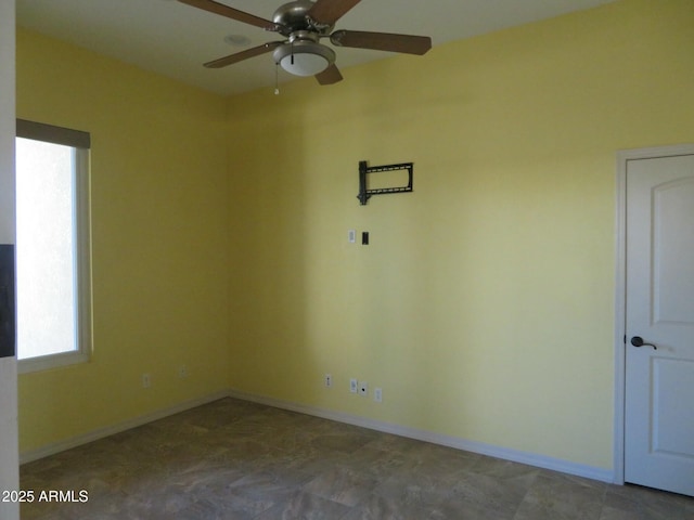 unfurnished room featuring baseboards and a ceiling fan