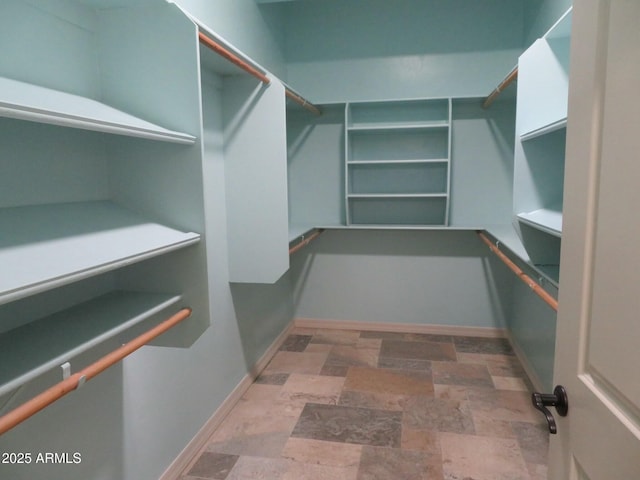 walk in closet with stone finish flooring