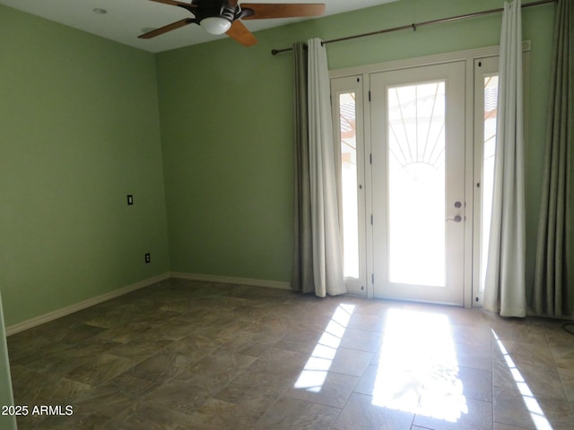 interior space with baseboards and ceiling fan