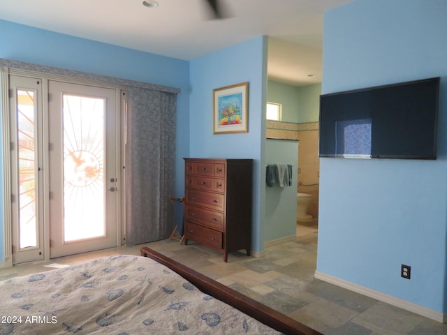 bedroom with ensuite bath, access to outside, and multiple windows