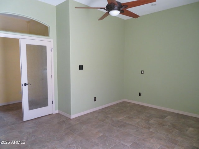 unfurnished room featuring a ceiling fan, baseboards, and french doors