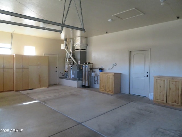 garage featuring heating unit and water heater