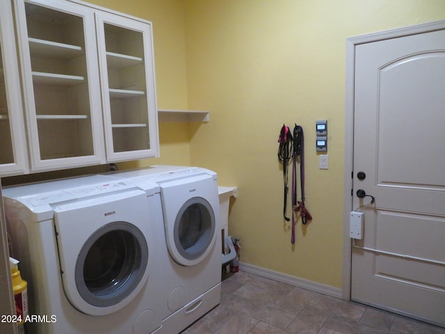 laundry room with washer and clothes dryer and cabinets