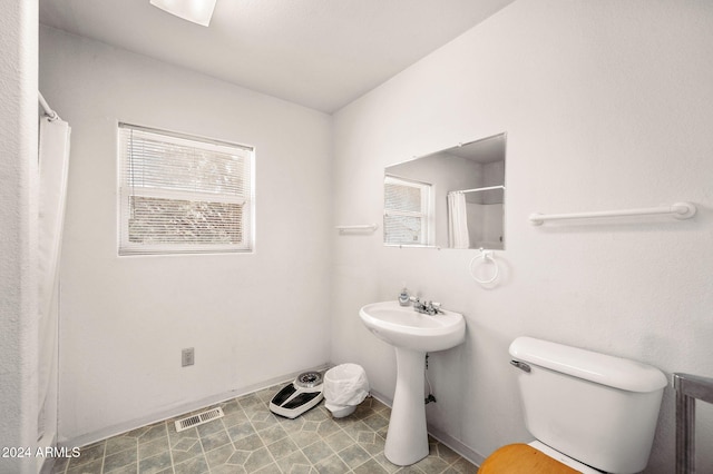 bathroom with a shower with curtain, tile patterned flooring, and toilet