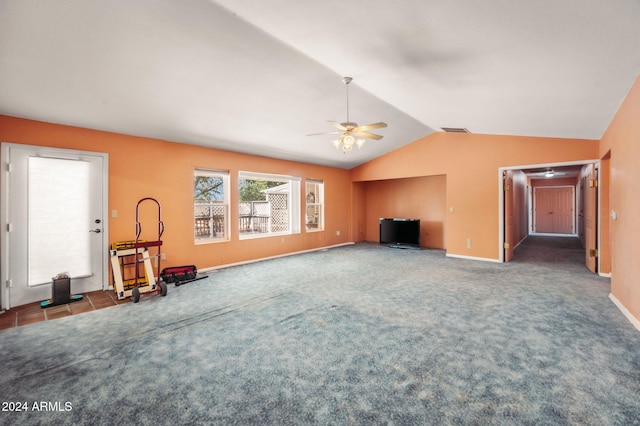 unfurnished living room with ceiling fan, vaulted ceiling, and dark carpet