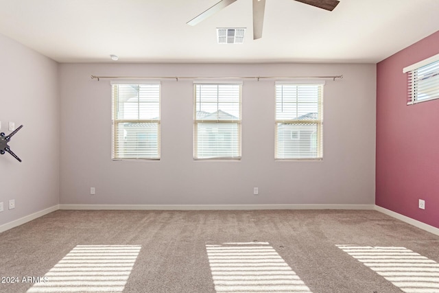 spare room with plenty of natural light, ceiling fan, and light colored carpet