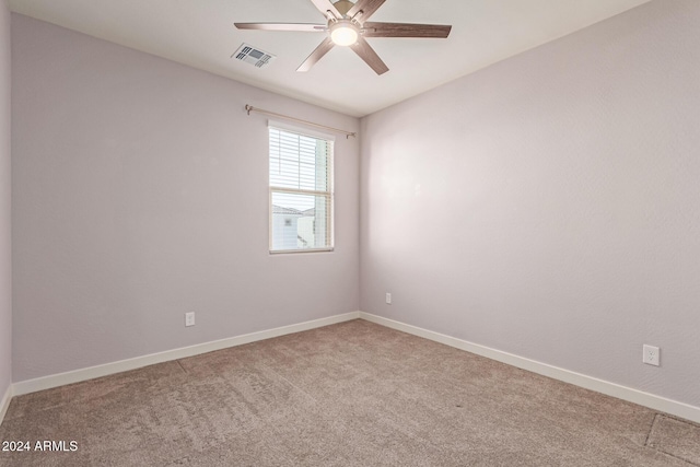 empty room featuring ceiling fan and light colored carpet