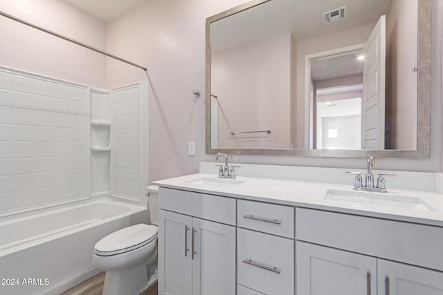 full bathroom featuring hardwood / wood-style floors, vanity, toilet, and bathtub / shower combination