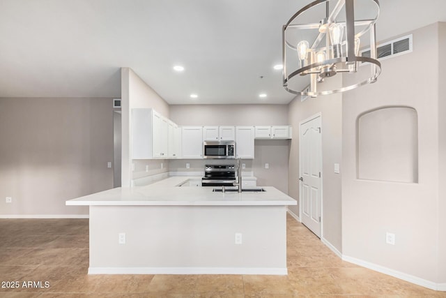 kitchen with kitchen peninsula, stainless steel appliances, sink, a chandelier, and white cabinetry