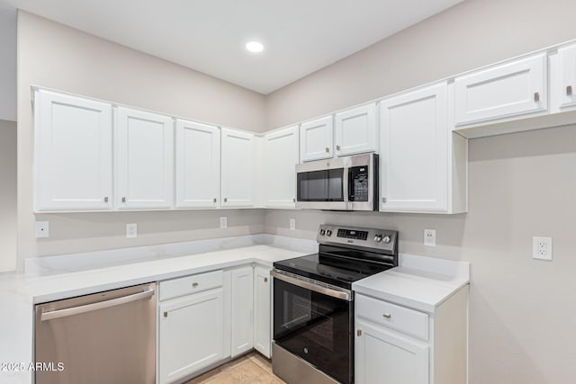 kitchen with light stone counters, white cabinets, and appliances with stainless steel finishes