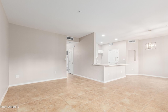 unfurnished living room featuring sink and an inviting chandelier