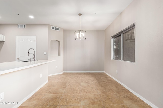 unfurnished dining area with sink and a notable chandelier