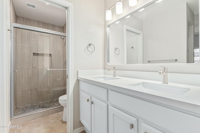 bathroom featuring tile patterned floors, vanity, toilet, and walk in shower