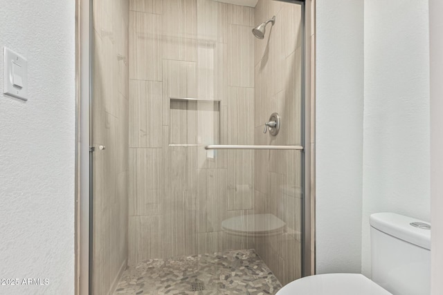 bathroom with an enclosed shower and toilet