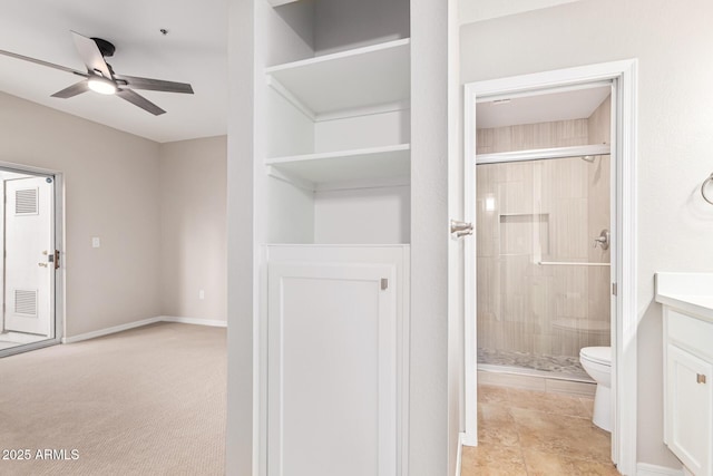 bathroom with ceiling fan, vanity, an enclosed shower, and toilet