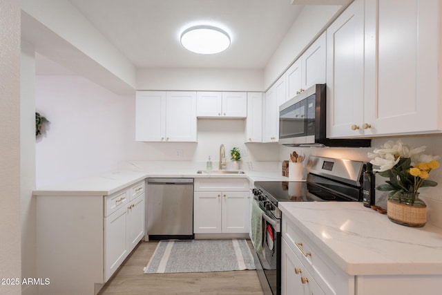 909 S Acapulco Ln Unit A, Tempe, AZ 85281 - kitchen featuring stainless steel appliances, a sink, light wood-style flooring, and white cabinetry