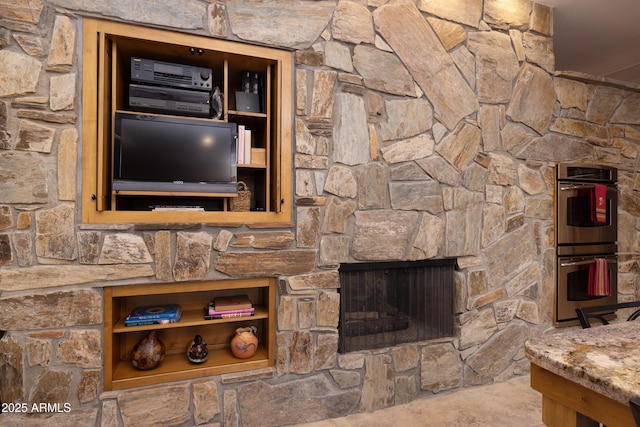 room details featuring stainless steel double oven and a fireplace