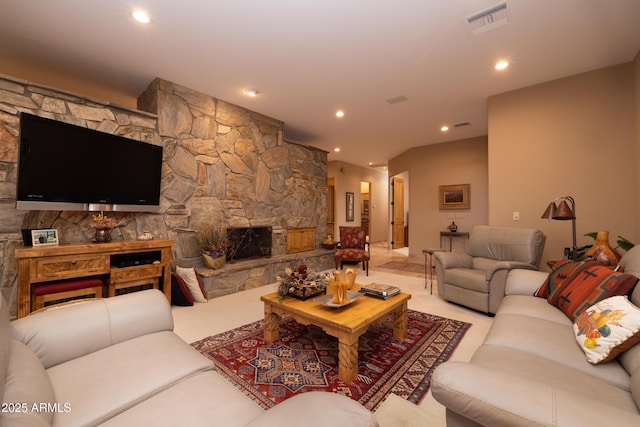 carpeted living room with a stone fireplace