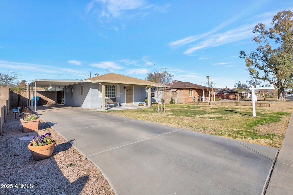 view of front of house featuring a carport and a front yard